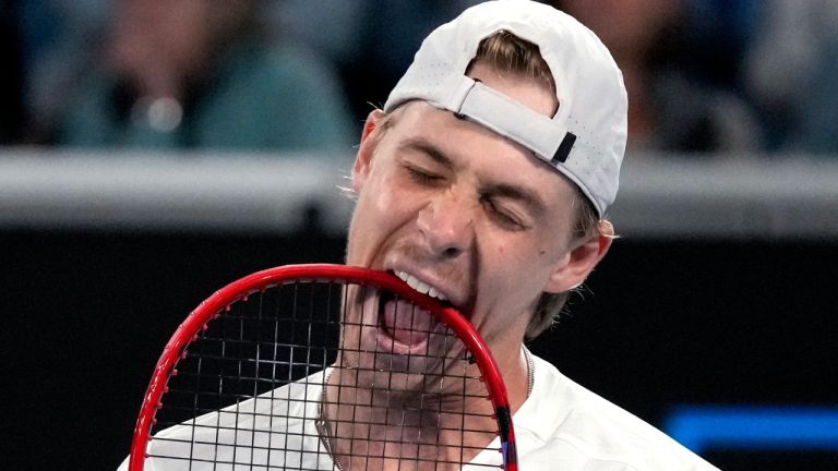Denis Shapovalov of Canada bites on his racket in frustration during his third round match against Hubert Hurkacz of Poland at the Australian Open tennis championship in Melbourne, Australia, Friday, Jan. 20, 2023.