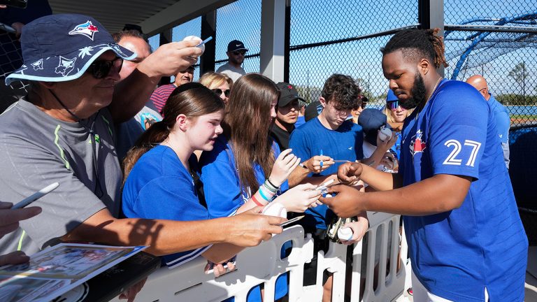 Toronto Blue Jays first baseman Vladimir Guerrero Jr., right, signs autographs for fans during baseball spring training in Dunedin, Fla., Monday, Feb. 20, 2023. (Nathan Denette/CP)