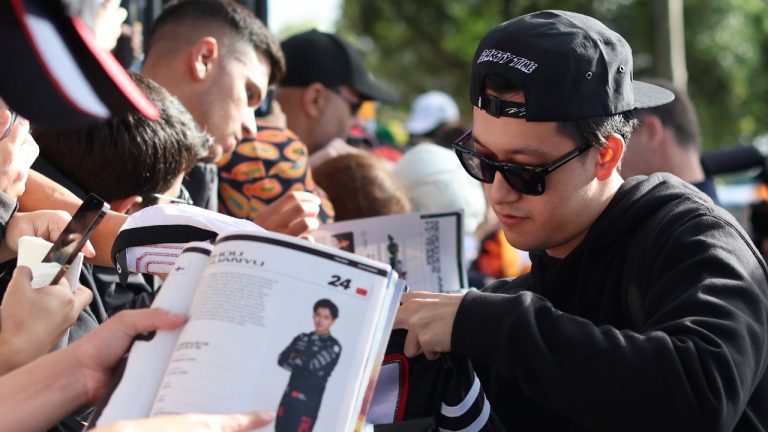 Alfa Romeo driver Zhou Guanyu, of China, signs autographs for fans as he arrives at the track ahead of the Australian Formula One Grand Prix at Albert Park in Melbourne, Friday, March 31, 2023. (Asanka Brendon Ratnayake/AP)