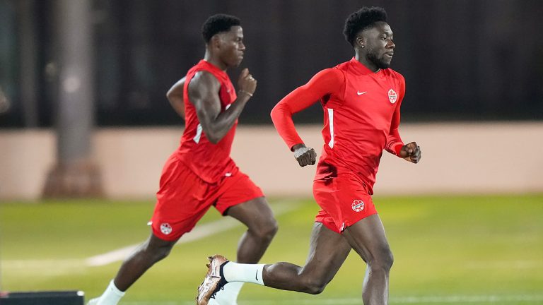 Canada forward Alphonso Davies, right, runs with teammate Jonathan David during practice at the World Cup in Doha, Qatar on Tuesday, November 29, 2022. (Nathan Denette/CP)