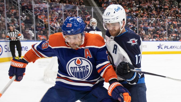 Winnipeg Jets' Adam Lowry (17) and Edmonton Oilers' Leon Draisaitl (29) battle for the puck during second period NHL action in Edmonton on Friday March 3, 2023. (Jason Franson/CP)