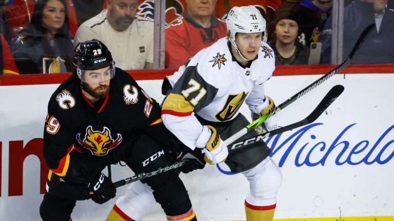 Vegas Golden Knights forward William Karlsson, right, is checked by Calgary Flames forward Dillon Dube during first period NHL hockey action in Calgary, Alta., Thursday, March 23, 2023. (Jeff McIntosh/CP)