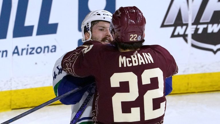 Arizona Coyotes' Jack McBain (22) Vancouver Canucks' Kyle Burroughs get into a shoving match during the second period of an NHL hockey game Thursday, March 16, 2023, in Tempe, Ariz. (Darryl Webb/AP Photo)
