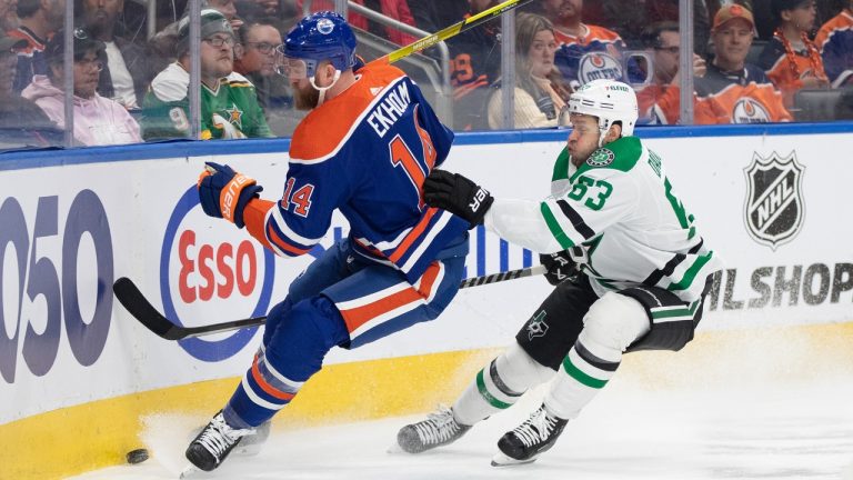 Dallas Stars' Evgenii Dadonov (63) and Edmonton Oilers' Mattias Ekholm (14) battle for the puck during first period NHL action in Edmonton on Thursday March 16, 2023. (Jason Franson/CP)