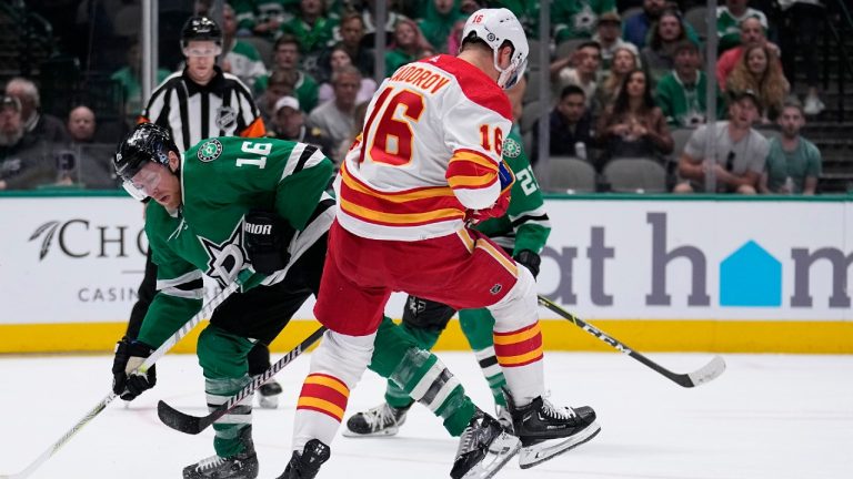 Dallas Stars' Joe Pavelski, left, and Calgary Flames' Nikita Zadorov, right, compete for control of the puck in the first period of an NHL hockey game, Monday, March 6, 2023, in Dallas. (Tony Gutierrez/AP)