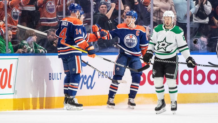 Dallas Stars' Evgenii Dadonov (63) skates past as Edmonton Oilers' Mattias Ekholm (14) and Connor McDavid (97) celebrate a goal during first period NHL action. (Jason Franson/CP)