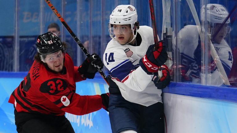 Canada's Mason McTavish (32) and United States' Brock Faber (14) skate behind the net during a preliminary round men's hockey game at the 2022 Winter Olympics, Saturday, Feb. 12, 2022, in Beijing. (Matt Slocum/AP)