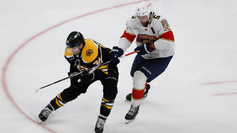 Boston Bruins' Jake DeBrusk tries to hold off Florida Panthers' Aaron Ekblad (5) from getting the puck during the third period of Game 1 of an NHL hockey playoff series Monday, April 17, 2023, in Boston. (Winslow Townson/AP)