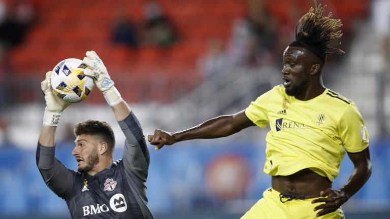Toronto FC keeper Alex Bono (25) grabs the ball beside Nashville SC forward CJ Sapong (17) during MLS soccer action in Toronto. (Cole Burston/THE CANADIAN PRESS)