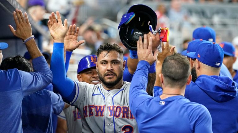 New York Mets' Omar Narvaez (2) is congratulated after scoring on a double by Brandon Nimmo during the seventh inning of the team's opening-day baseball game against the Miami Marlins, Thursday, March 30, 2023, in Miami. (Lynne Sladky/AP)