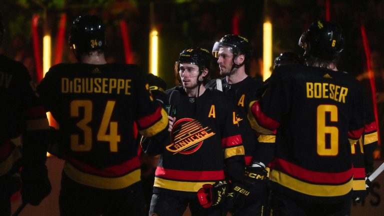 Vancouver Canucks' Quinn Hughes, centre, addresses the fans after defeating the Calgary Flames in their final NHL hockey home game of the year, in Vancouver, on Saturday, April 8, 2023. (Darryl Dyck/CP)