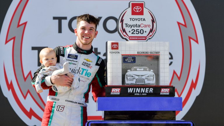 Chandler Smith poses next to the trophy with his baby after winning a NASCAR Xfinity Series auto race at Richmond Raceway on Saturday, April 1, 2023, in Richmond, Va. (Mike Caudill/AP)