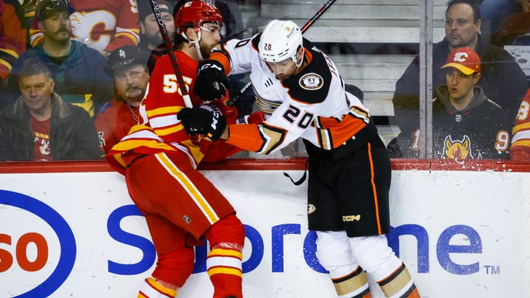 Anaheim Ducks forward Brett Leason, right, checks Calgary Flames defenceman Noah Hanifin during second period NHL hockey action in Calgary, Sunday, April 2, 2023. (Jeff McIntosh/CP)