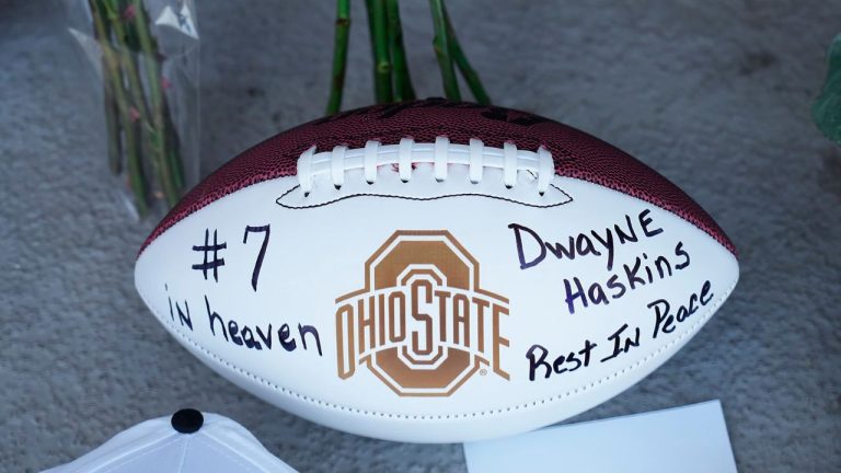 Football, roses, and other items at a makeshift memorial for former Ohio State football player and Pittsburgh Steelers quarterback Dwayne Haskins Jr., at a memorial at Ohio Stadium on the campus of Ohio State University, Sunday, April 10, 2022. (AP)