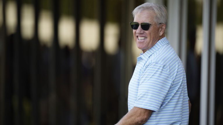 Denver Broncos outside consultant and former quarterback John Elway jokes with reporters as players take part in drills during the NFL football team's training camp Friday, Aug. 5, 2022, at the Broncos' headquarters in Centennial, Colo. (David Zalubowski/AP)
