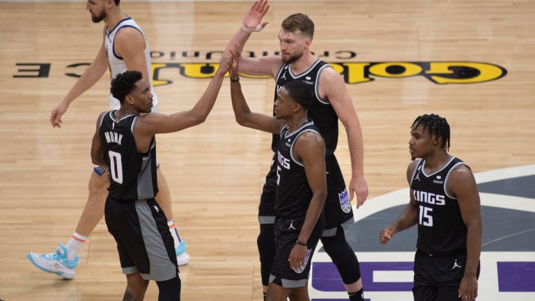 Sacramento Kings guard Malik Monk (0) congratulates guard De'Aaron Fox (5), forward Domantas Sabonis, top right, and guard Davion Mitchell (15) in the final seconds in the fourth quarter during Game 1 against the Golden State Warriors in the first round of the NBA basketball playoffs in Sacramento, Calif., Saturday, April 15, 2023. (José Luis Villegas/AP)