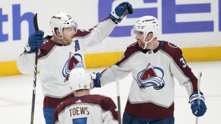 Colorado Avalanche centre Nathan MacKinnon (29) celebrates with defenseman Devon Toews (7) and left wing J.T. Compher (37) after scoring during overtime of an NHL hockey game in Anaheim, Calif., Sunday, April 9, 2023. The Avalanche won 5-4. (Ashley Landis/AP)