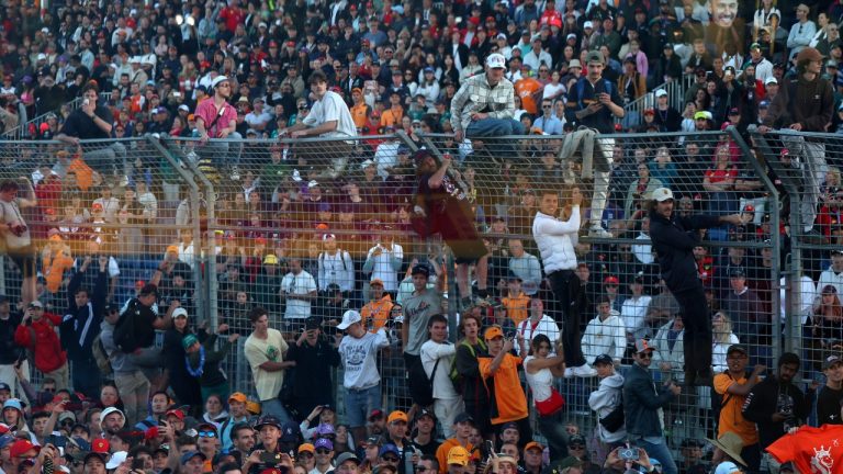 Fans scale a fence and flood into the track at the end of the Australian Formula One Grand Prix at Albert Park in Melbourne, Sunday, April 2, 2023. (Asanka Brendon Ratnayake/AP Photo)