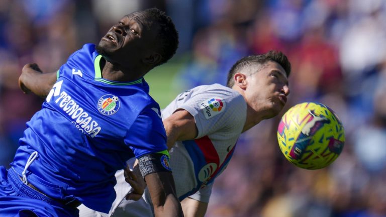 Getafe's Djene Dakonam, left, fights for the ball with Barcelona's Robert Lewandowski during a Spanish La Liga soccer match between Getafe and FC Barcelona at the Coliseum Alfonso Perez stadium in Getafe, Spain, Sunday, April 16, 2023. (Manu Fernandez/AP)