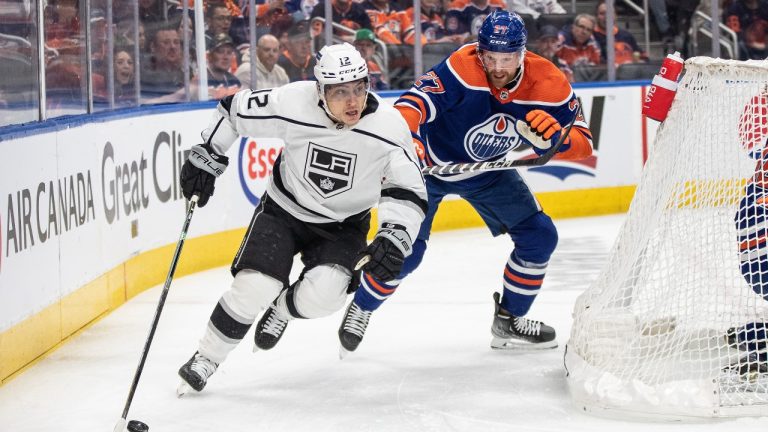 Los Angeles Kings' Trevor Moore (12) and Edmonton Oilers' Brett Kulak (27) battle for the puck during first period NHL Stanley Cup first round playoff action in Edmonton on Tuesday April 25, 2023. (Jason Franson/THE CANADIAN PRESS)