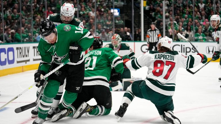 Dallas Stars center Joe Pavelski works to take control of the puck in front of Minnesota Wild defenseman Jake Middleton (5) as Jason Robertson (21) and Kirill Kaprizov (97) collide during play in the first period of Game 1 of an NHL hockey Stanley Cup first-round playoff series, Monday, April 17, 2023, in Dallas. (Tony Gutierrez/AP Photo)