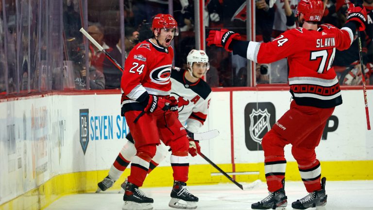 Carolina Hurricanes' Seth Jarvis (24) celebrates his goal with Jaccob Slavin (74) with New Jersey Devils' Jack Hughes (86) during the first period of Game 1 of an NHL hockey Stanley Cup second-round playoff series in Raleigh, N.C., Wednesday, May 3, 2023. (Karl B DeBlaker/AP)