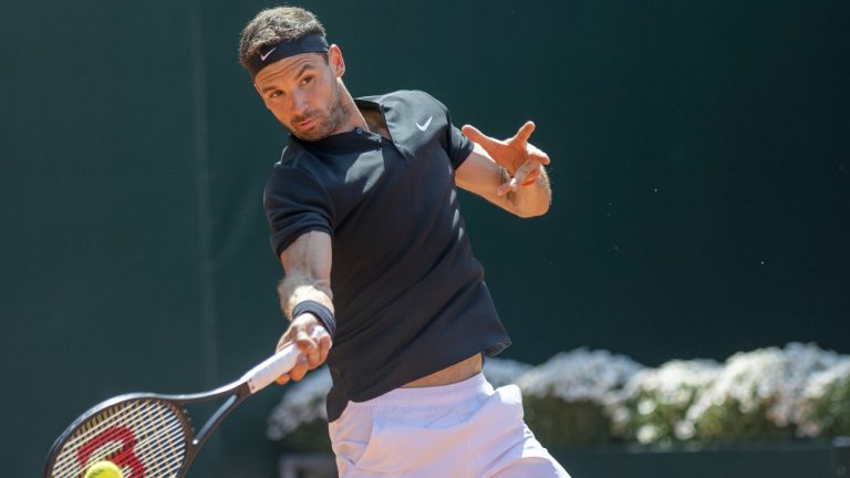 Grigor Dimitrov of Bulgaria returns a ball to Taylor Fritz of the United States during their semi-final match at the Geneva Open tennis tournament in Geneva, Switzerland, Friday, May 26, 2023. (Martial Trezzini/Keystone via AP)