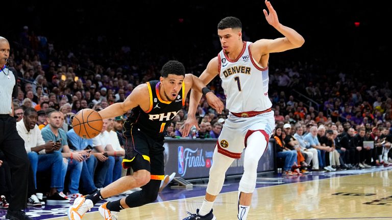 Phoenix Suns guard Devin Booker, left, drives as Denver Nuggets forward Michael Porter Jr. defends during the first half of Game 3 of an NBA basketball Western Conference semifinal game, Friday, May 5, 2023, in Phoenix. (Matt York/AP)