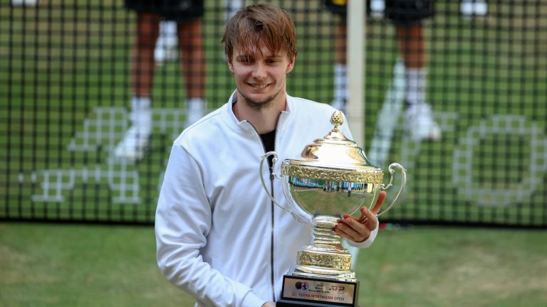 Kazakhstan's Alexander Bublik holds the trophy after beating Russia's Andrey Rublev and winning the German Tennis Open, in Halle, Germany, Sunday, June 25, 2023. (Friso Gentsch/dpa via AP)