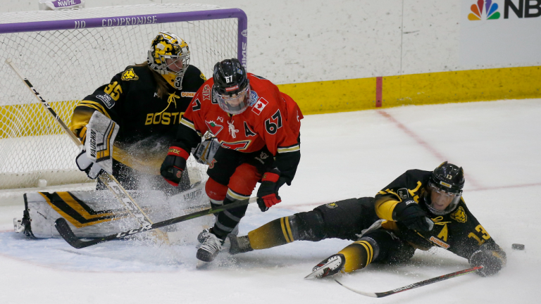 Toronto Six forward Emma Woods (67) looks for a rebound as Boston Pride defender Kaleigh Fratkin (13) slides to the clear the puck ahead of goalie Lovisa Selander (35) during the second period of a semifinal in the NWHL Isobel Cup hockey tournament Friday, March 26, 2021, in Boston. (AP)