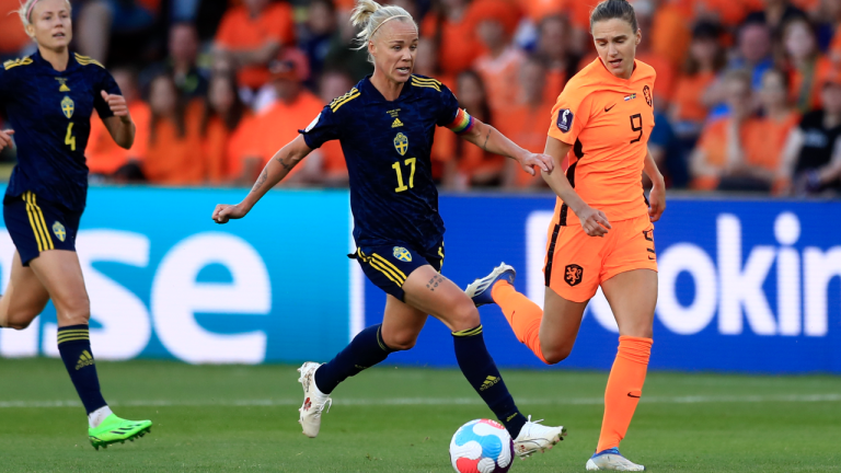 Sweden's Caroline Seger runs with the ball watched by Netherlands' Vivianne Miedema, right, during the Women Euro 2022 group C soccer match between the Netherlands and Sweden at Bramall Lane, Sheffield, England, Saturday, July 9, 2022. (AP)