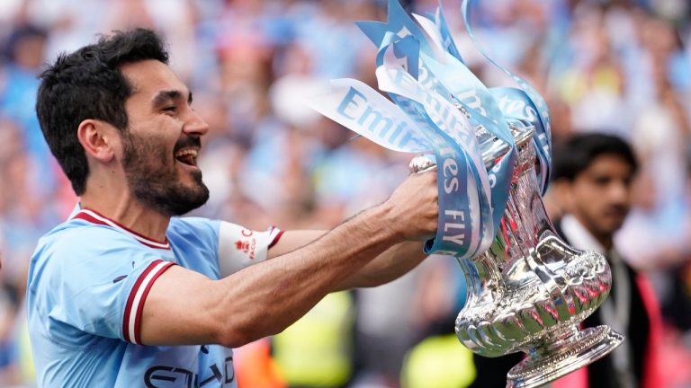 Manchester City's Ilkay Gundogan holds up the winners trophy as he celebrates winning the English FA Cup final soccer match between Manchester City and Manchester United at Wembley Stadium in London, Saturday, June 3, 2023. Manchester City won 2-1. (Dave Thompson/AP)