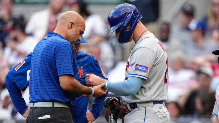 A member of the New York Mets training staff checks first baseman Pete Alonso (20) hand after he was hit by a pitch from Atlanta Braves starting pitcher Charlie Morton (50) in the first inning a baseball game against the Atlanta Braves, Wednesday, June 7, 2023, in Atlanta. (AP Photo/John Bazemore)