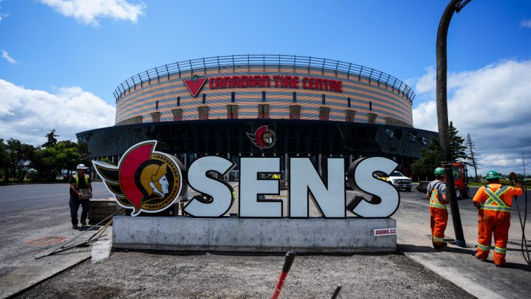 Landscapers work around Ottawa Senators NHL team signage at the Canadian Tire Centre in Ottawa on Tuesday, June 13, 2023. (Sean Kilpatrick/CP)