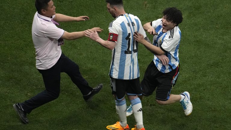 A security person tries to catch a Chinese fan who ran into field and hug Soccer superstar Lionel Messi during a friendly soccer match against Australia at the Worker's Stadium in Beijing, Thursday, June 15, 2023. (AP Photo/Ng Han Guan)