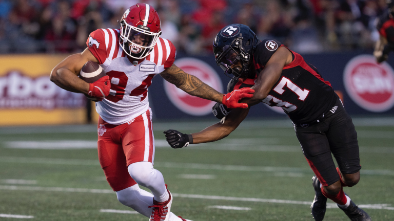 Calgary Stampeders wide receiver Reggie Begelton, left, breaks free of a tackle from Ottawa Redblacks defensive back Brandin Dandridge during first half CFL action, Thursday, June 15, 2023 in Ottawa. (Adrian Wyld/CP)