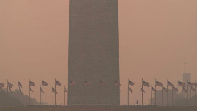 People run at the base of the Washington Monument and a thick layer of smoke covering Thursday, June 8, 2023, in Washington. Intense Canadian wildfires are blanketing the northeastern U.S. in a dystopian haze, turning the air acrid, the sky yellowish gray and prompting warnings for vulnerable populations to stay inside. (Jose Luis Magana/AP Photo)