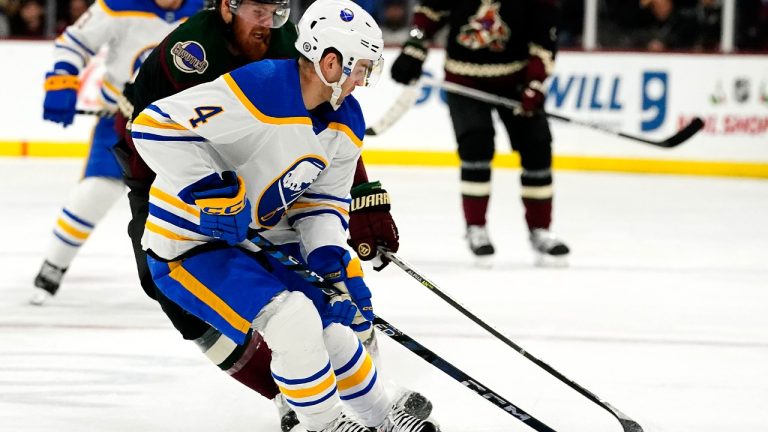 Buffalo Sabres' Jeremy Davis (4) and Arizona Coyotes' Lawson Crouse (67) battle for the puck in the first period during an NHL hockey game, Saturday, Dec. 17, 2022, in Tempe, Ariz. (Darryl Webb/AP)