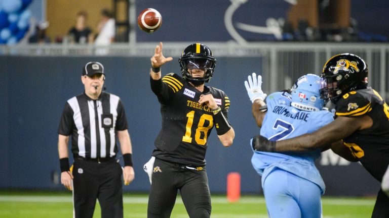 Hamilton Tiger-Cats quarterback Matt Shiltz (18) throws the ball while defended by Toronto Argonauts defensive lineman Folarin Orimolade (7) during second half CFL action, in Toronto, on Sunday, June 18. (CP)
