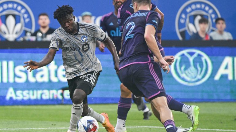 CF Montreal's Kwadwo Opoku (90) moves by Charlotte FC's Jan Sobocinski (2) during first half MLS soccer action in Montreal, Saturday, July 15, 2023. (Graham Hughes/CP)