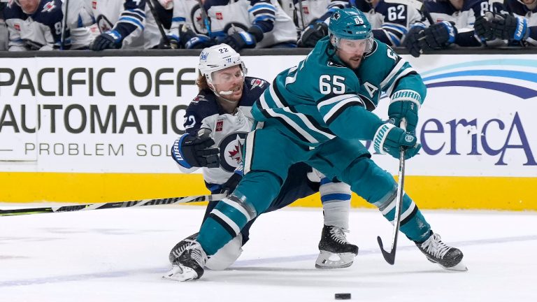 San Jose Sharks defenceman Erik Karlsson (65) is defended by Winnipeg Jets center Mason Appleton (22) during the second period of an NHL hockey game Tuesday, March 28, 2023, in San Jose, Calif. (Tony Avelar/AP)