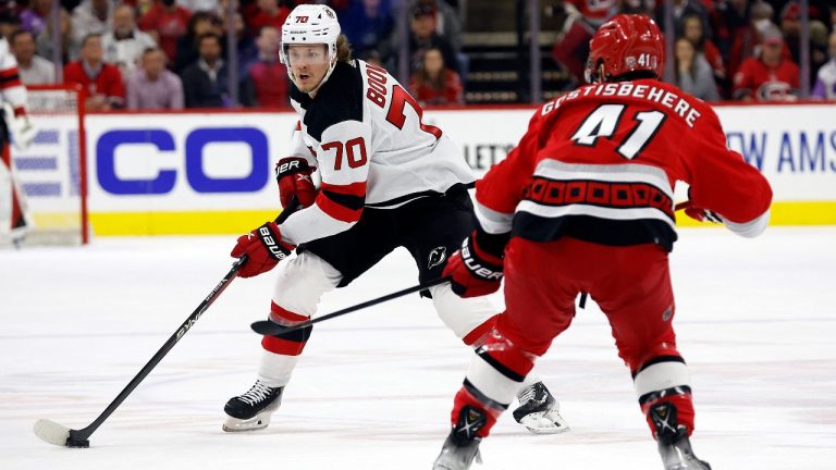 New Jersey Devils' Jesper Boqvist (70) controls the puck as he approaches Carolina Hurricanes' Shayne Gostisbehere (41) during the first period of Game 1 of an NHL hockey Stanley Cup second-round playoff series in Raleigh, N.C., Wednesday, May 3, 2023. (Karl B DeBlaker/AP)