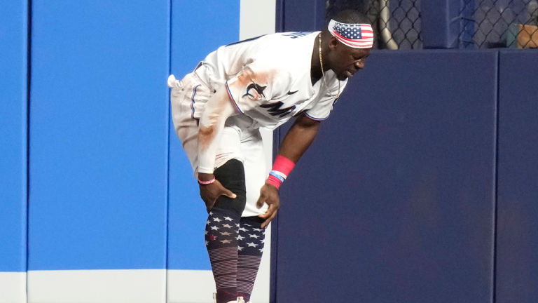 Miami Marlins centre fielder Jonathan Davis holds his knee after an injury during the fifth inning of a baseball game against the St. Louis Cardinals, Tuesday, July 4, 2023, in Miami. (AP Photo/Lynne Sladky)