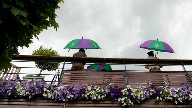 Britain Wimbledon Tennis
Stewards stand under umbrellas after a rain delay on day three of the Wimbledon tennis championships in London, Wednesday, July 5, 2023. (AP)
