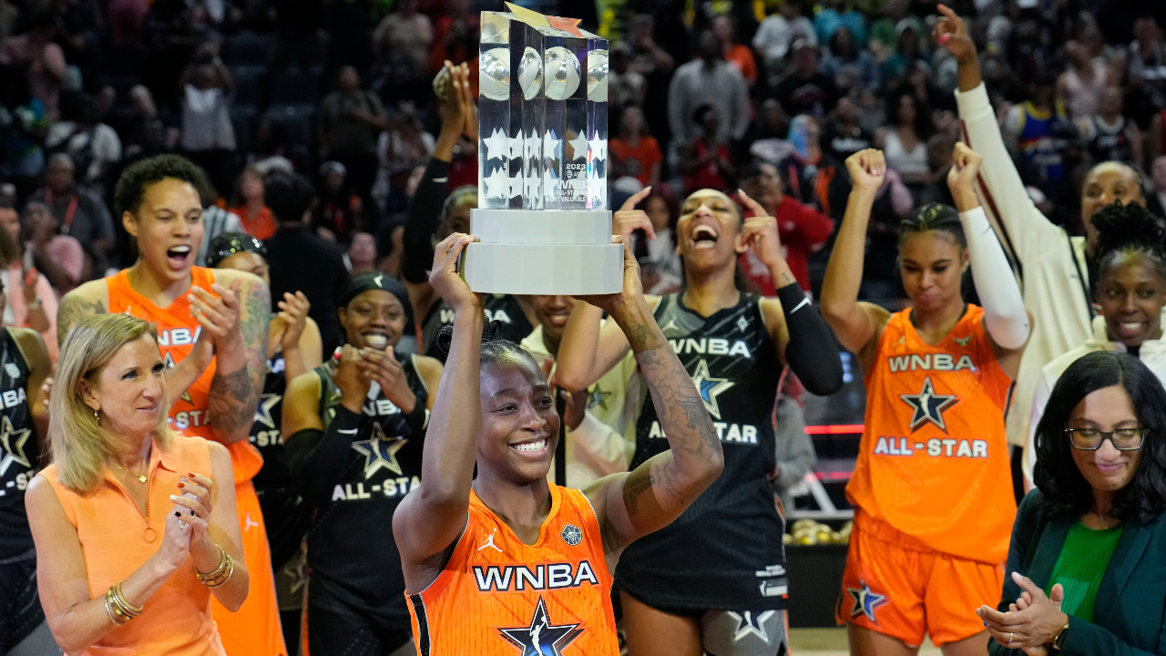 Arike Ogunbowale of Team WNBA holds up the MVP trophy after the