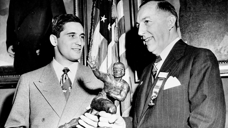 Notre Dame's Johnny Lujack, left, receives the Heisman Memorial Trophy from Wilbur Jurden, president of the Downtown A.C, at the Downtown Athletic Club in New York. (AP)
