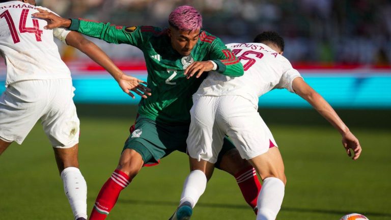 Mexico defender Julián Araujo tries to get past Qatar defender Homam Ahmed, left, and midfielder Mostafa Meshaal, right, during the first half of a CONCACAF Gold Cup soccer match, Sunday, July 2, 2023, in Santa Clara, Calif. (AP Photo/Godofredo A. Vásquez)