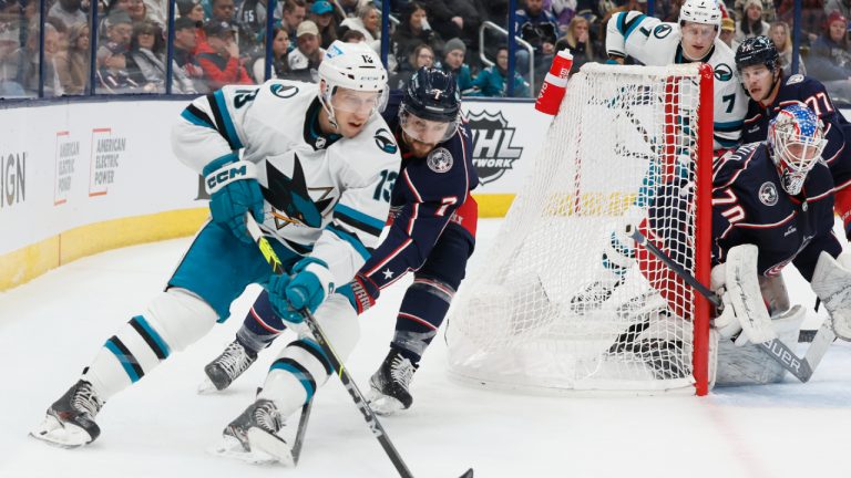 San Jose Sharks' Nick Bonino, left, carries the puck behind the net as Columbus Blue Jackets' Sean Kuraly defends during the first period of an NHL hockey game on Saturday, Jan. 21, 2023, in Columbus, Ohio. (Jay LaPrete/AP)