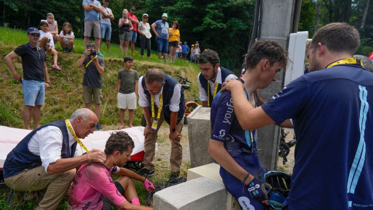 Britain's James Shaw, left, gets medical assistance as France's Romain Bardet, second right, talks to his team, after both riders crashed and retired from the race during the fourteenth stage of the Tour de France cycling race over 152 kilometers (94.5 miles) with start in Annemasse and finish in Morzine Les Portes du Soleil, France. (Thibault Camus/AP)