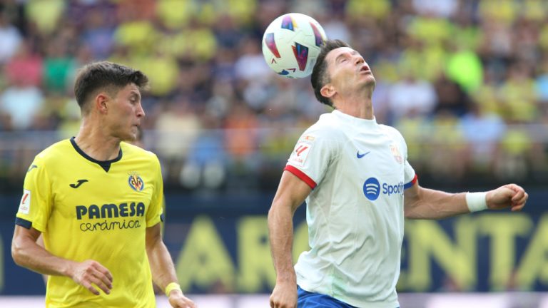Barcelona's Robert Lewandowski, right, back heads the ball in front of Villarreal's Jorge Cuenca during a Spanish La Liga soccer match between Villarreal and Barcelona at the Ceramica stadium in Villarreal, Spain, Sunday, Aug. 27, 2023. (Alberto Saiz/AP) 